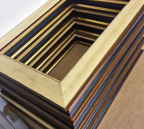 Stack of wooden picture frame mouldings in various finishes