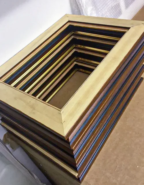 Stack of wooden picture frame mouldings in various finishes
