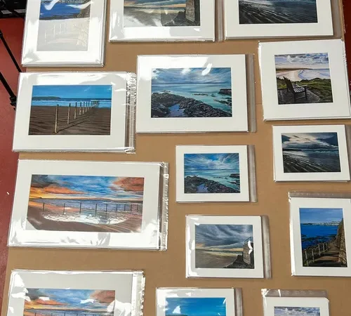 Collection of mounted landscape photographs laid out on a studio table